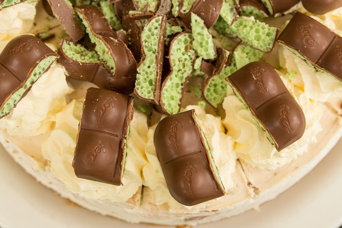 A Mint Aero cheesecake topped with chunks of Mint Aero chocolate and whipped cream